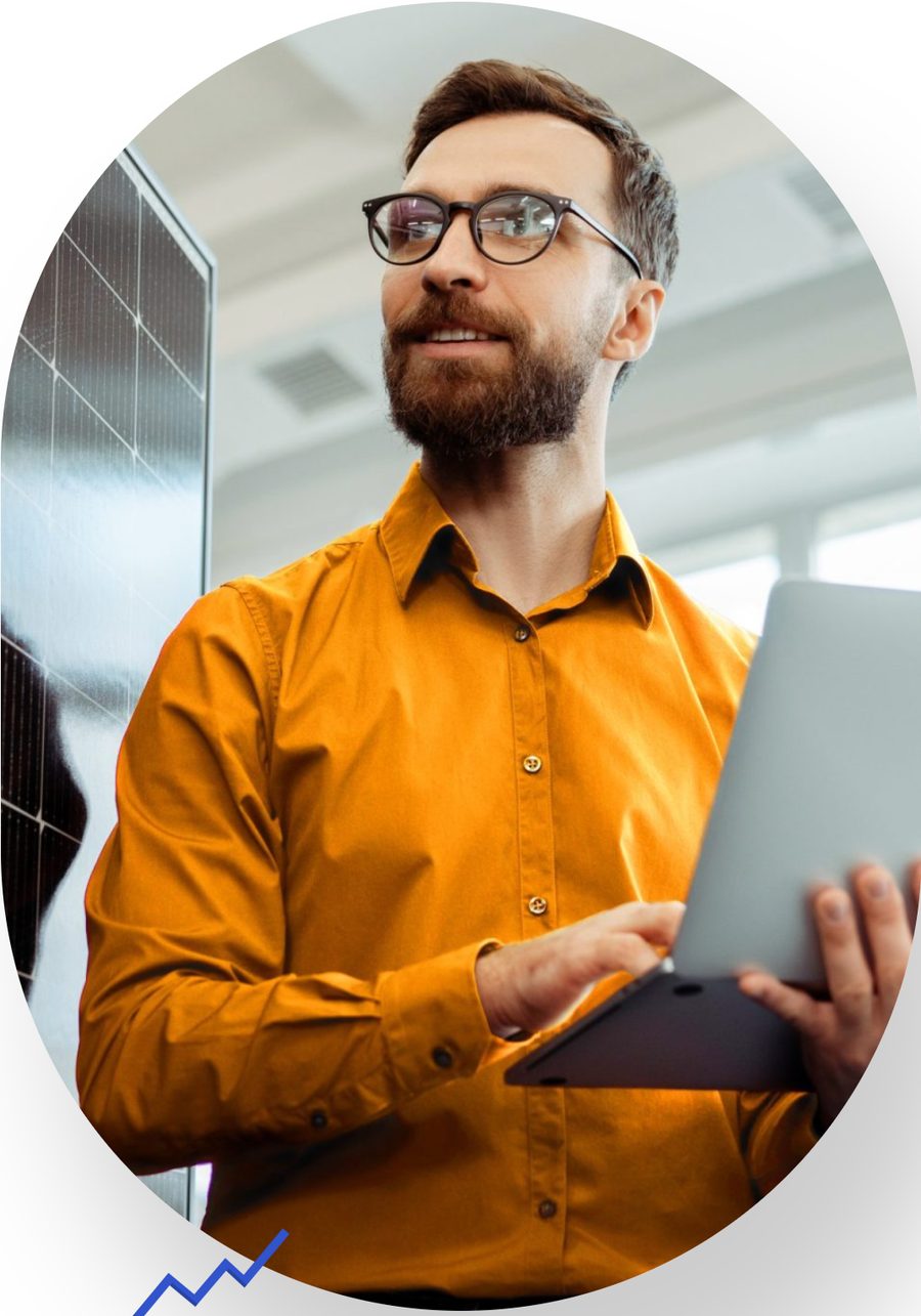 Solar engineer with a laptop beside a panel array